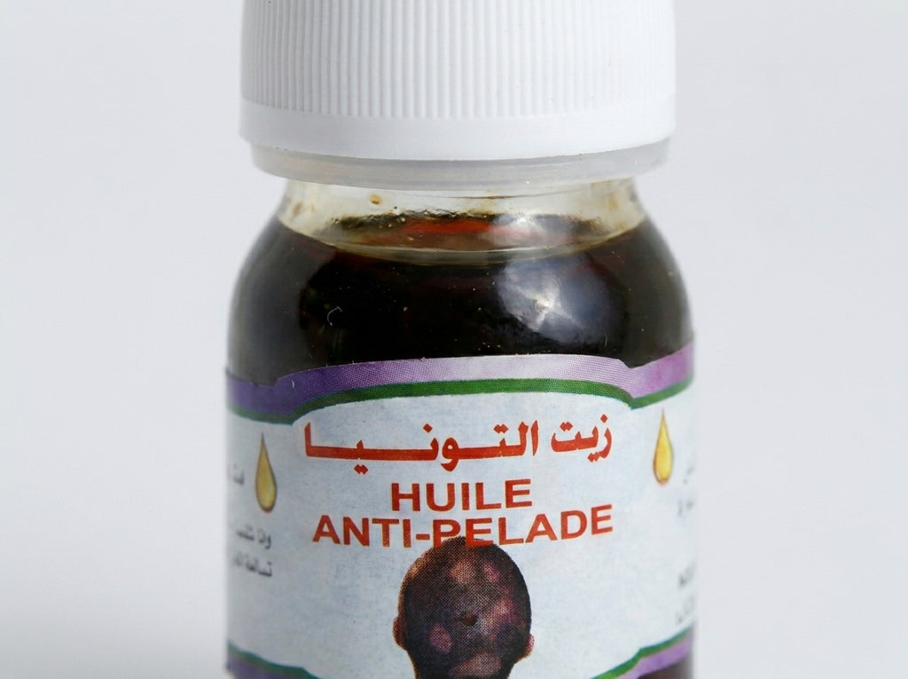 Application ciblée du sérum anti-pelade sur le cuir chevelu pour stimuler et réveiller les follicules.