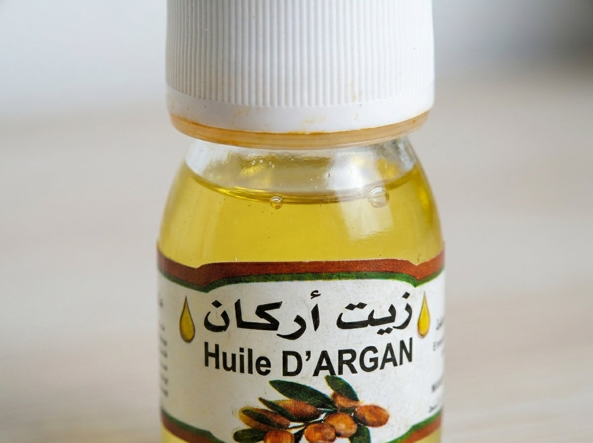 Application de l'huile d'argan pure sur les pointes de cheveux pour nourrir la fibre et restaurer l'éclat.