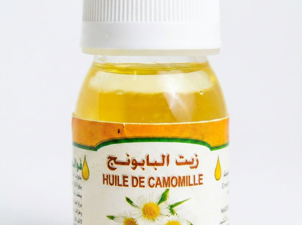 Application de l'huile de camomille pure sur le visage pour calmer les irritations et illuminer le teint.