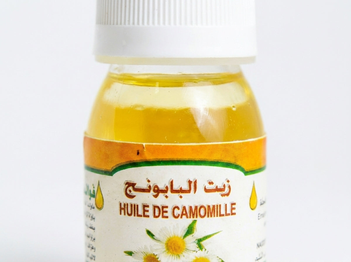 Application de l'huile de camomille pure sur le visage pour calmer les irritations et illuminer le teint.