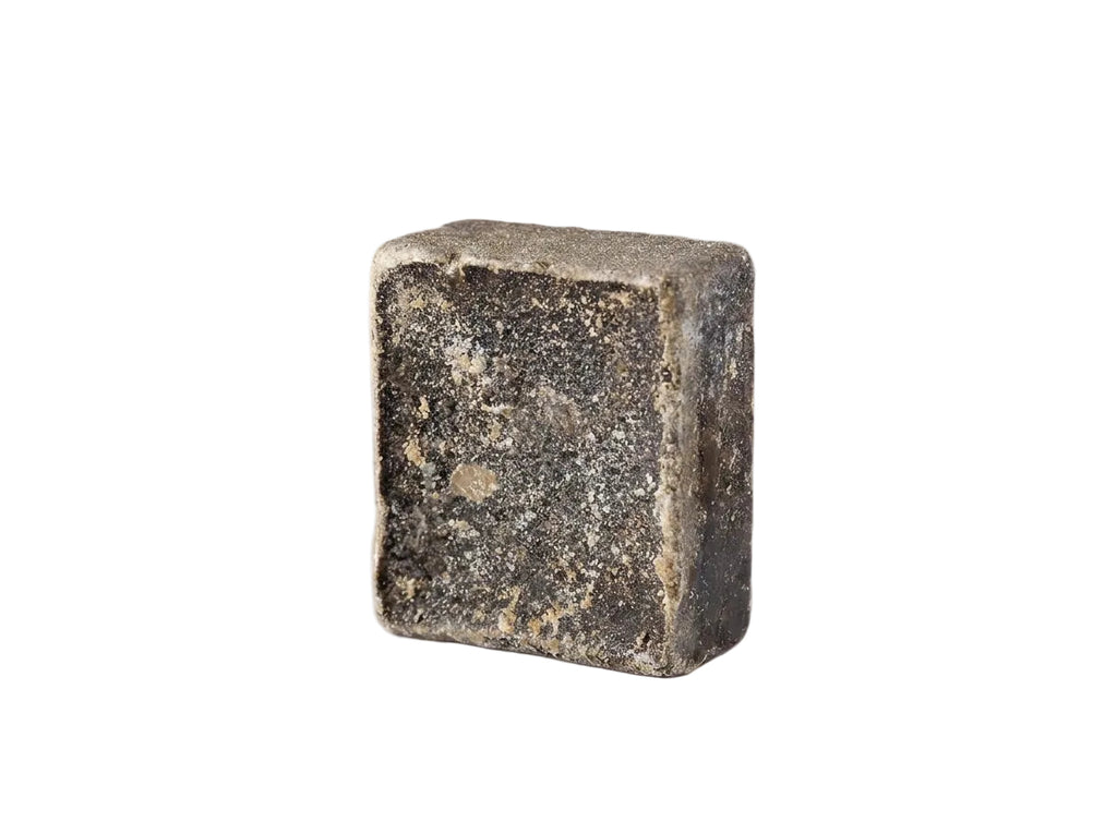 Mise en scène herboriste du musc solide entouré d'encens brut et d'étoffes d'hiver protectrices.