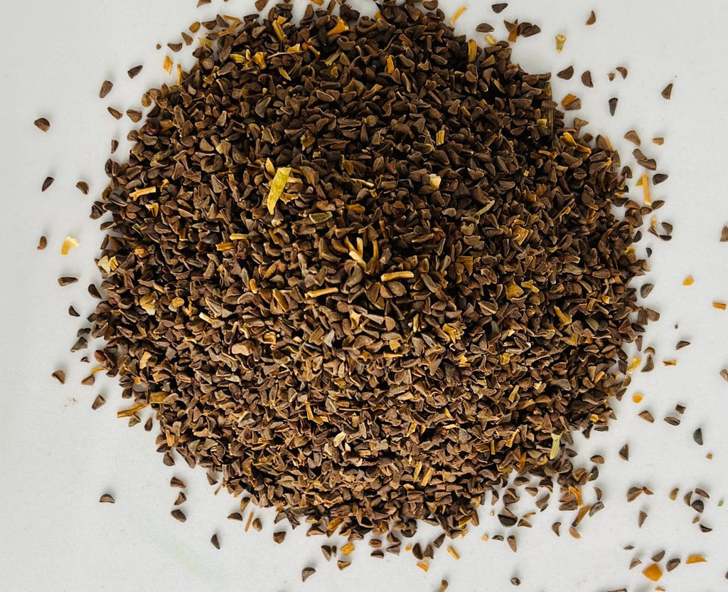 Gros plan macro détaillé sur la forme anguleuse et la couleur brune authentique des graines de Harmal pures d'Orianza.
