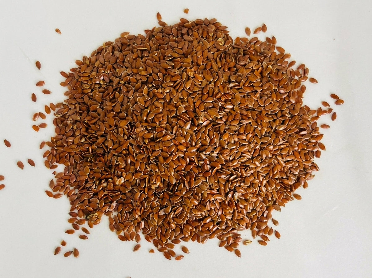 Gros plan macro sur la brillance naturelle et la qualité supérieure des graines de lin brun entières d'Orianza.