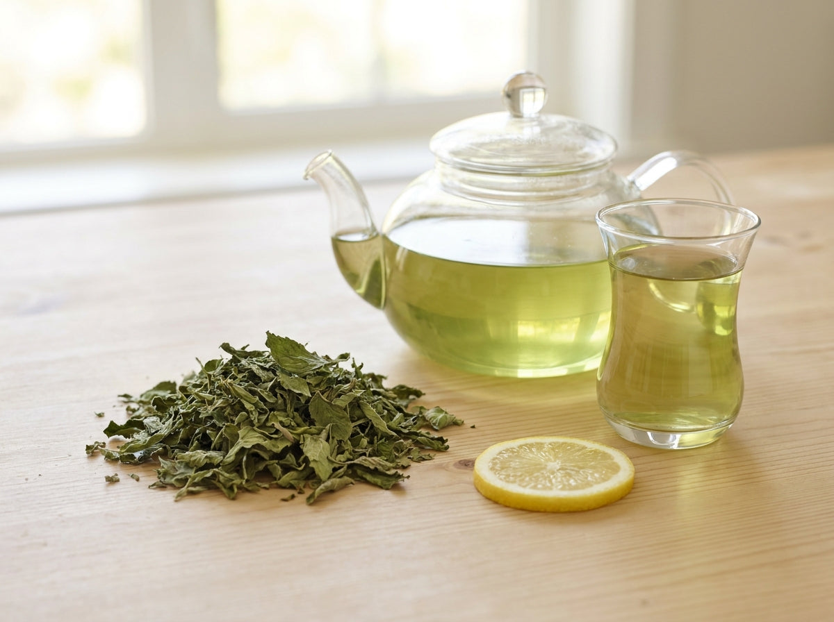 Théière traditionnelle en verre libérant un thé vert fumant parfumé au Fliou d'Orianza pour une digestion facile.