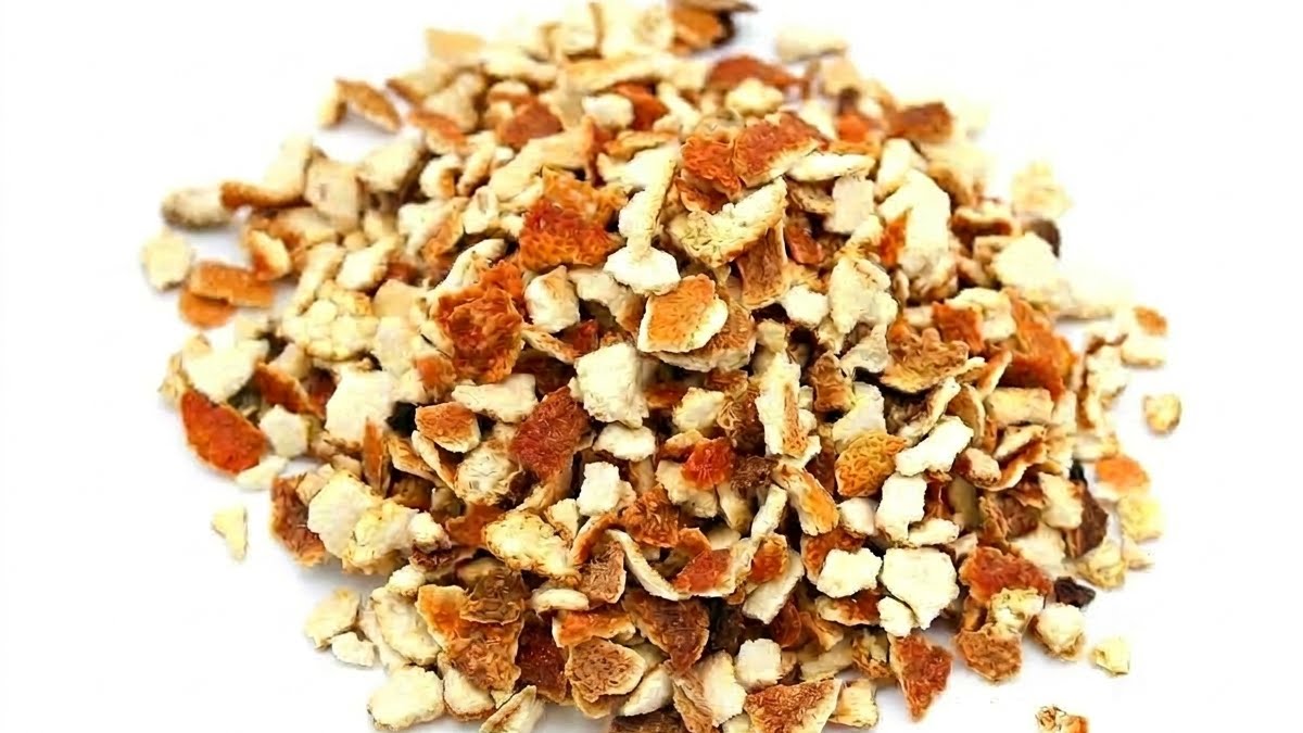 Gros plan herboriste sur les lanières d'écorces d'orange coupées et séchées, riches en huiles essentielles de limonène.