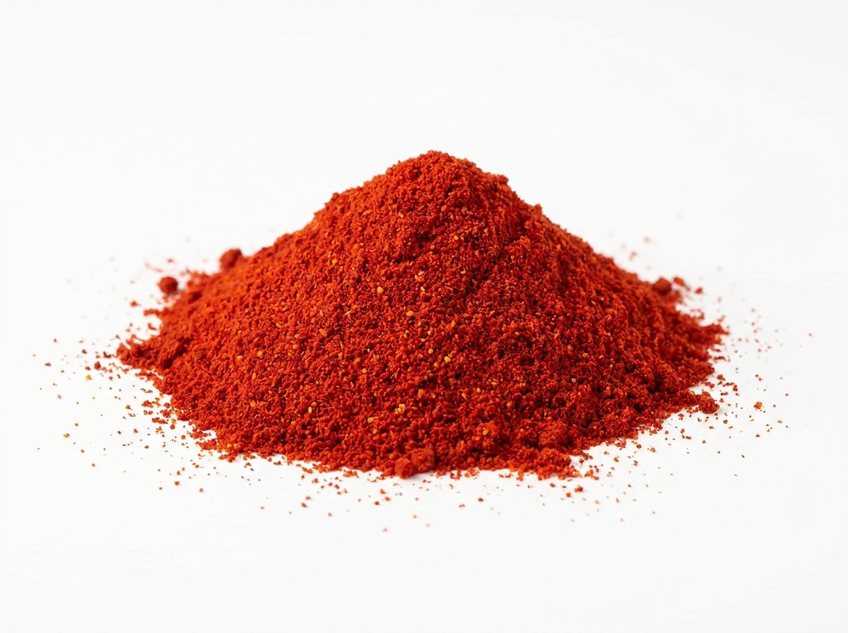 Gros plan herboriste sur la texture fine et fluide de la poudre de paprika doux, riche en pigments naturels.