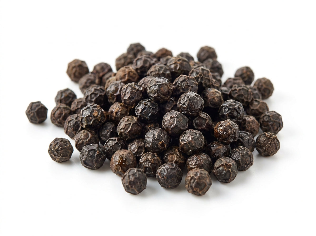 Gros plan herboriste sur des grains de poivre noir ridés et entiers, riches en pipérine et huiles essentielles.