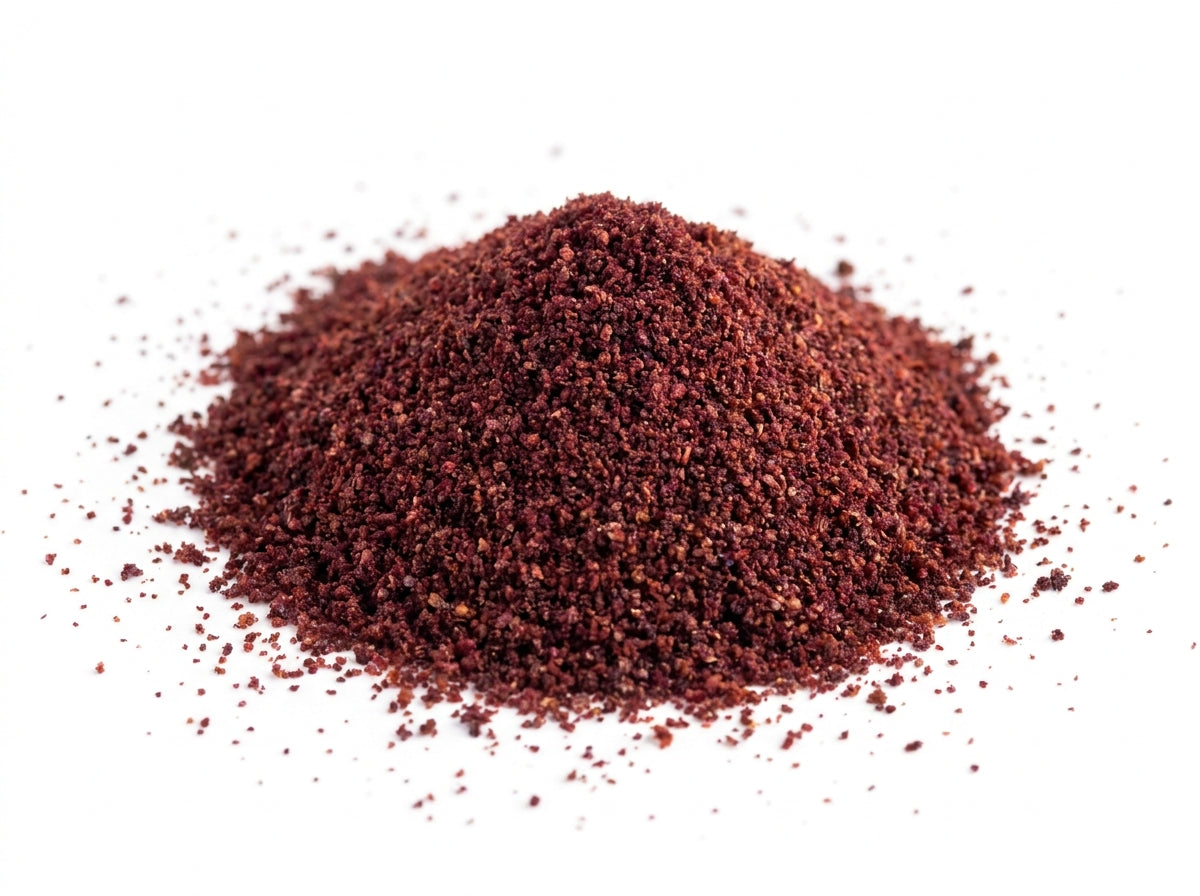 Gros plan sur la texture fine et la robe pourpre intense de la poudre de sumac sauvage riche en antioxydants.