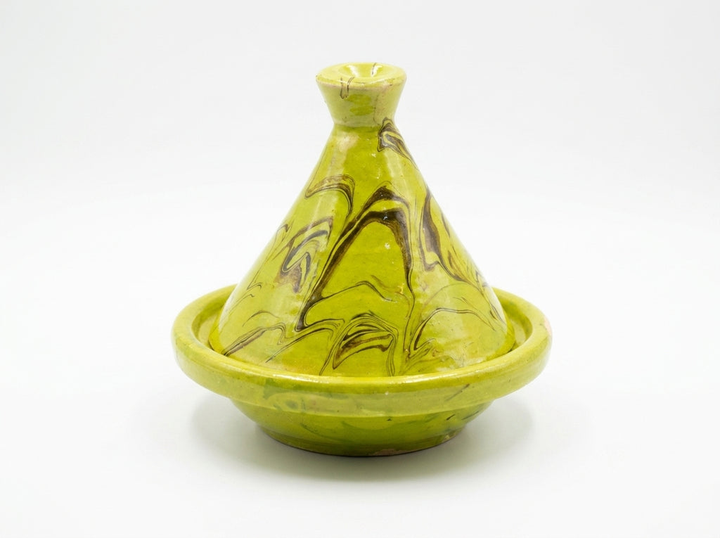 Petit tajine en terre cuite émaillée servant de porte-bijoux chic avec des bagues dorées déposées à l'intérieur.